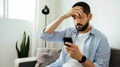 En la foto: Hombre preocupado con celular en la mano